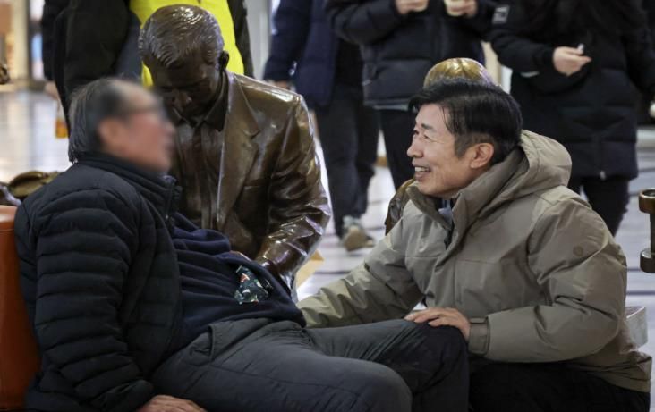 새해 첫날인 1일 고속터미널 대합실을 찾은 전성수 구청장(오른쪽)이 노숙인들의 안전을 확인하며 격려하고 있다.