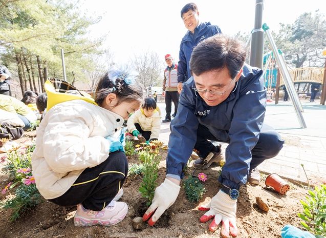 진교훈 서울 강서구청장(오른쪽)이 23일 방화근린공원에서 열린 ‘제81회 식목일 나무 심기 행사’에서 아이들과 꽃을 심고 있다.